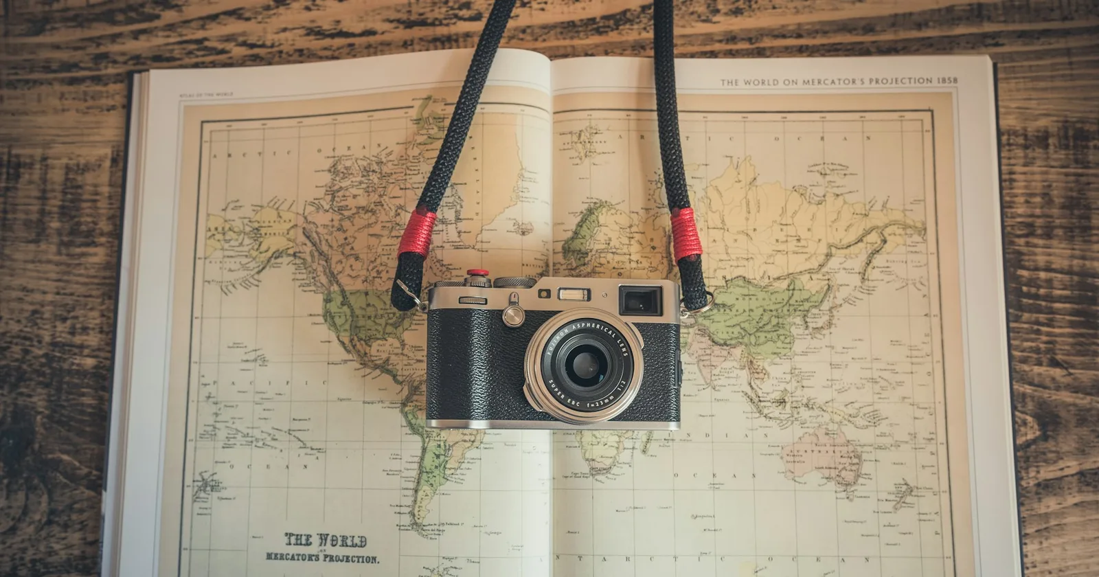 A camera resting on a map during travel planning
