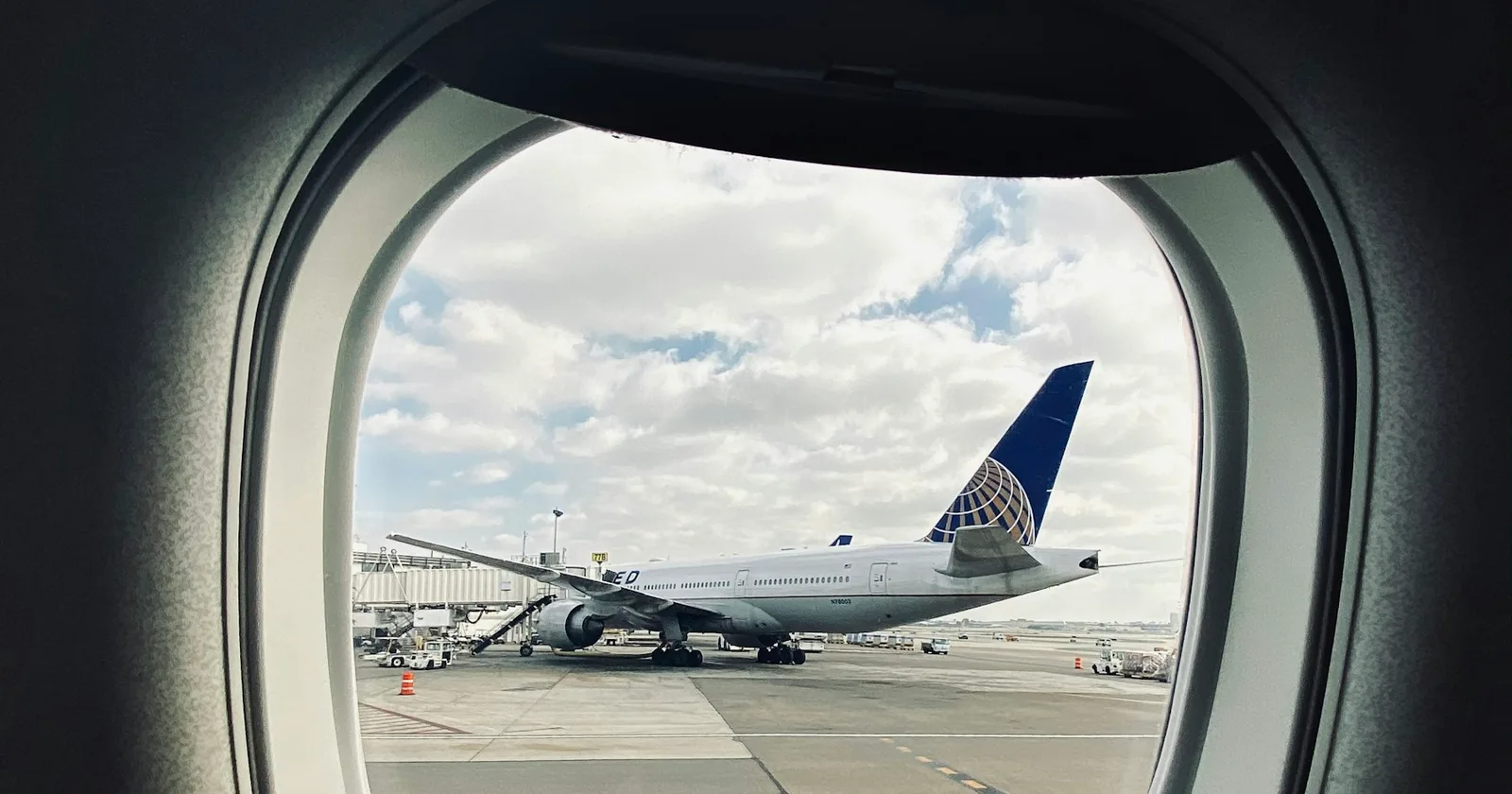 An aircraft at an airport gate seen through a cabin window